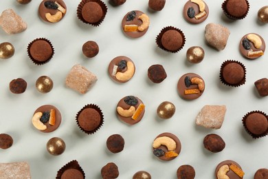 Photo of Different delicious chocolate candies on light background, flat lay