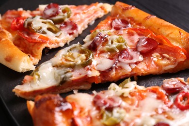 Photo of Pieces of delicious pizza Diablo on textured board, closeup