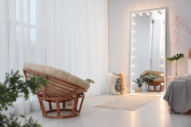 Large mirror with light bulbs in stylish room interior