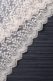 White lace on black table, top view. Space for text