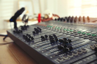 Photo of Professional mixing console on table in modern radio studio, closeup
