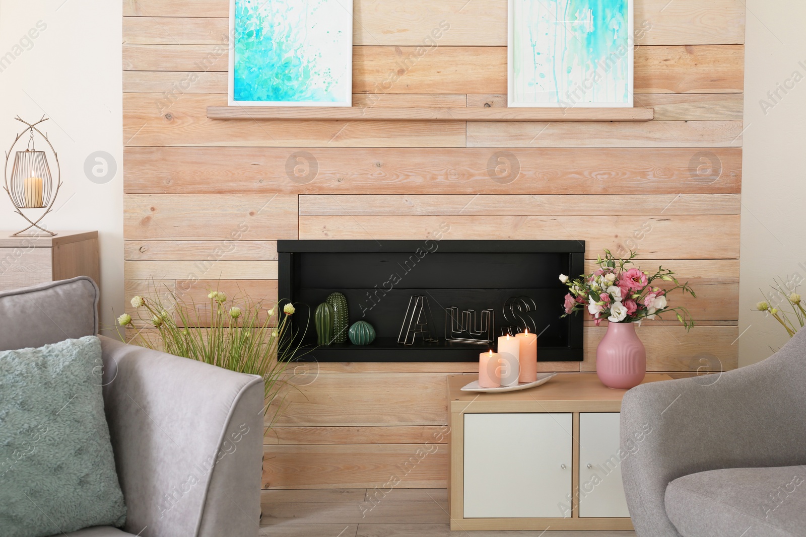 Photo of Stylish living room interior with burning candles on table