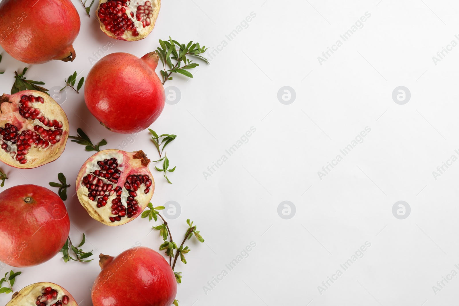 Photo of Flat lay composition with ripe pomegranates on white background. Space for text