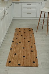 Stylish rug with dots on floor in kitchen