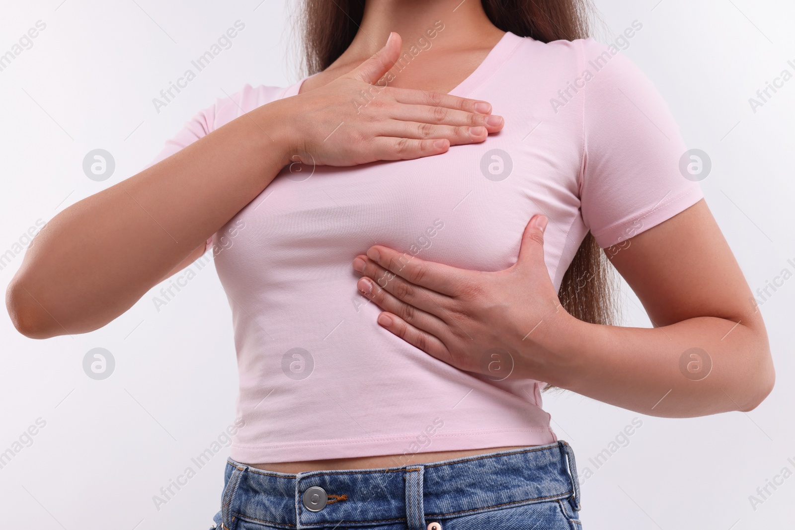 Photo of Woman doing breast self-examination on white background, closeup