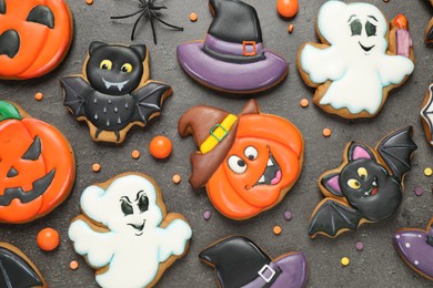 Photo of Tasty cookies and sweets for Halloween party on black table, flat lay