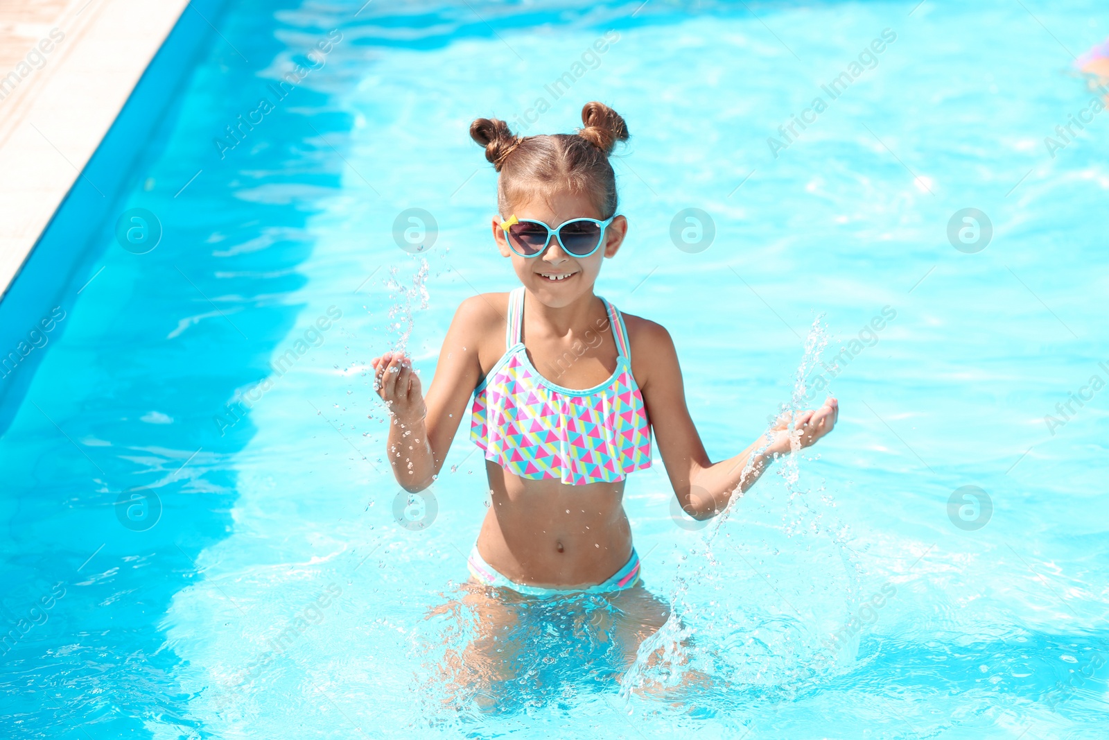 Photo of Happy little girl having fun in swimming pool