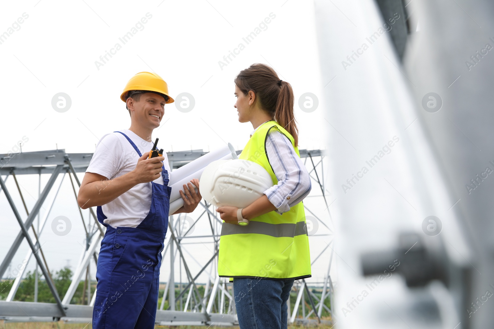 Photo of Professional engineers working on installation of electrical substation outdoors