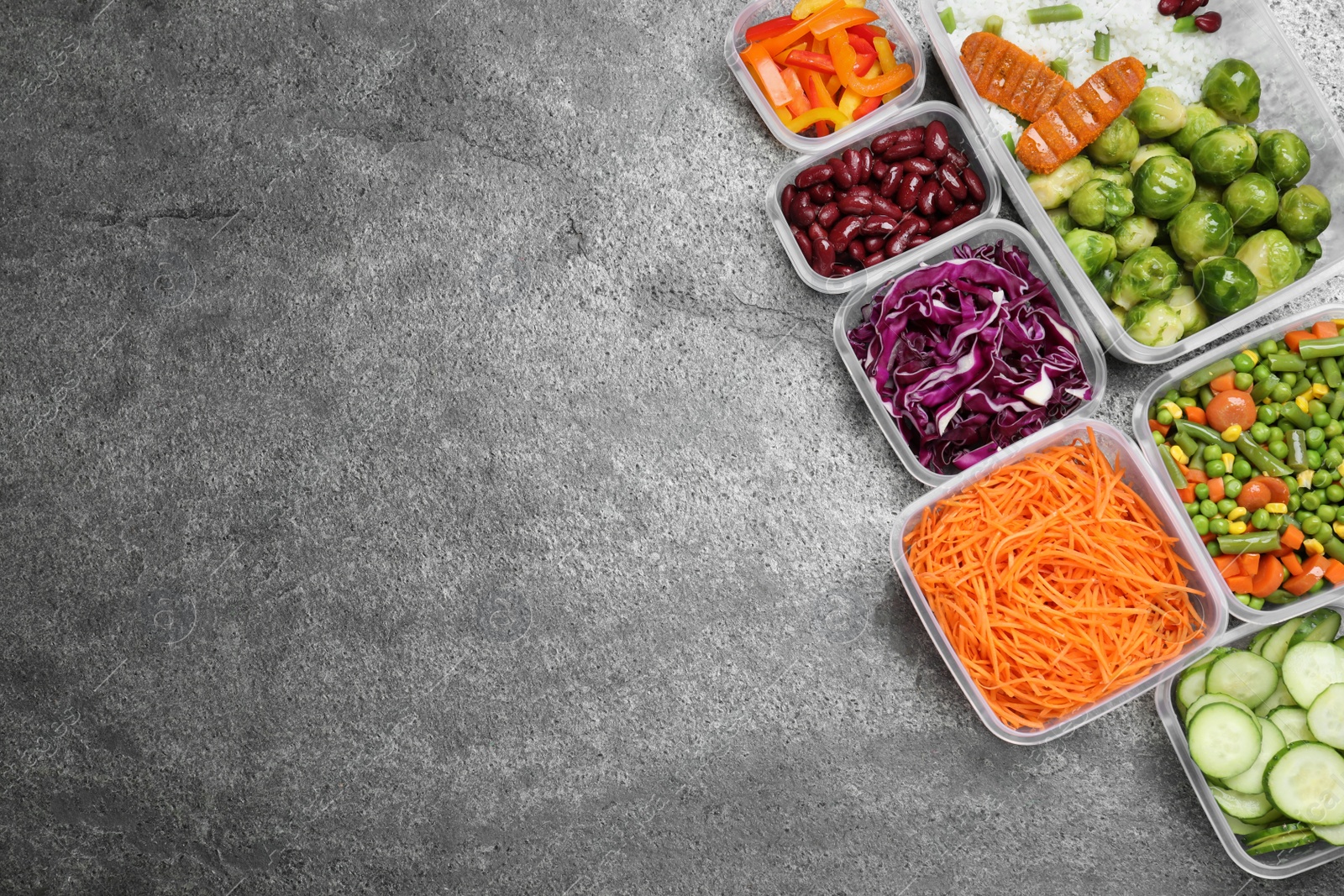 Photo of Set of plastic containers with fresh food on grey   table, flat lay. Space for text