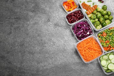 Photo of Set of plastic containers with fresh food on grey   table, flat lay. Space for text