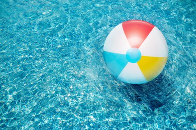 Image of Inflatable beach ball floating in swimming pool, above view 