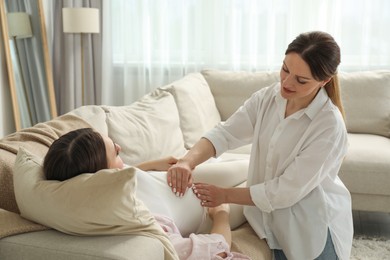 Doula taking care of pregnant woman at home. Preparation for child birth