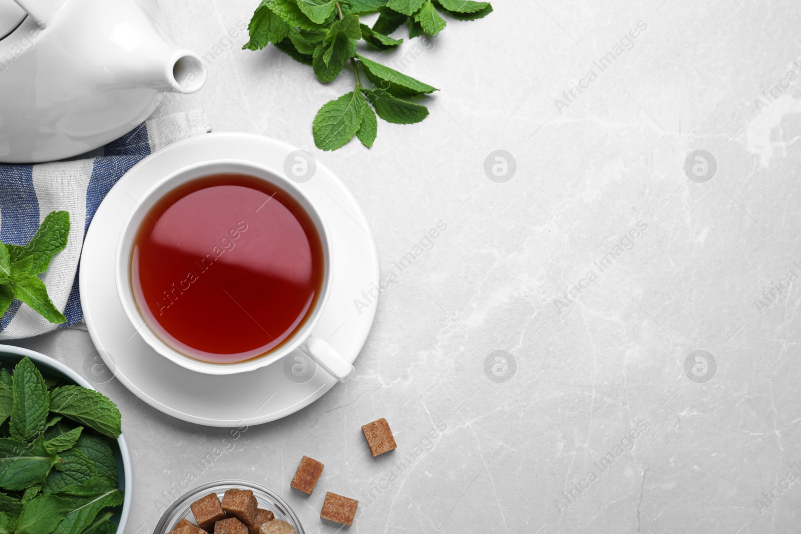 Photo of Composition with cup of hot aromatic mint tea on light table, flat lay. Space for text