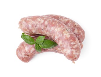 Photo of Raw homemade sausages and basil leaves isolated on white, top view