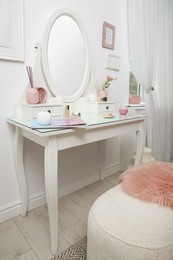 Photo of Dressing table with decor near white wall in room