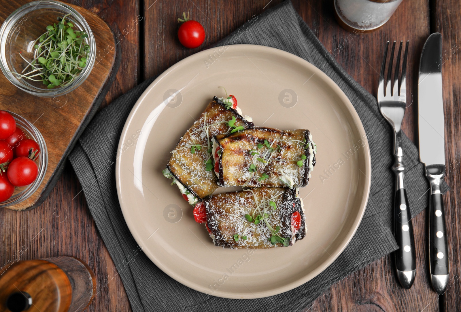 Photo of Delicious baked eggplant rolls served on wooden table, flat lay