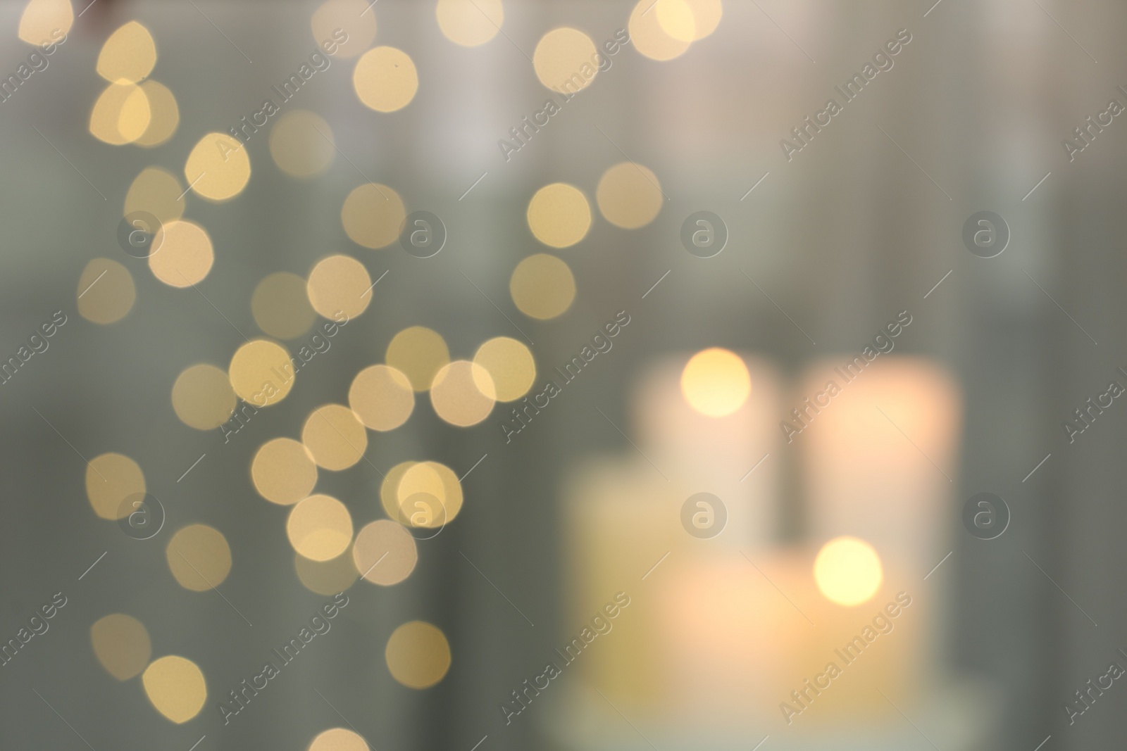 Photo of Blurred view of burning candles indoors. Bokeh effect