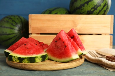 Slices of delicious ripe watermelon on light blue wooden table