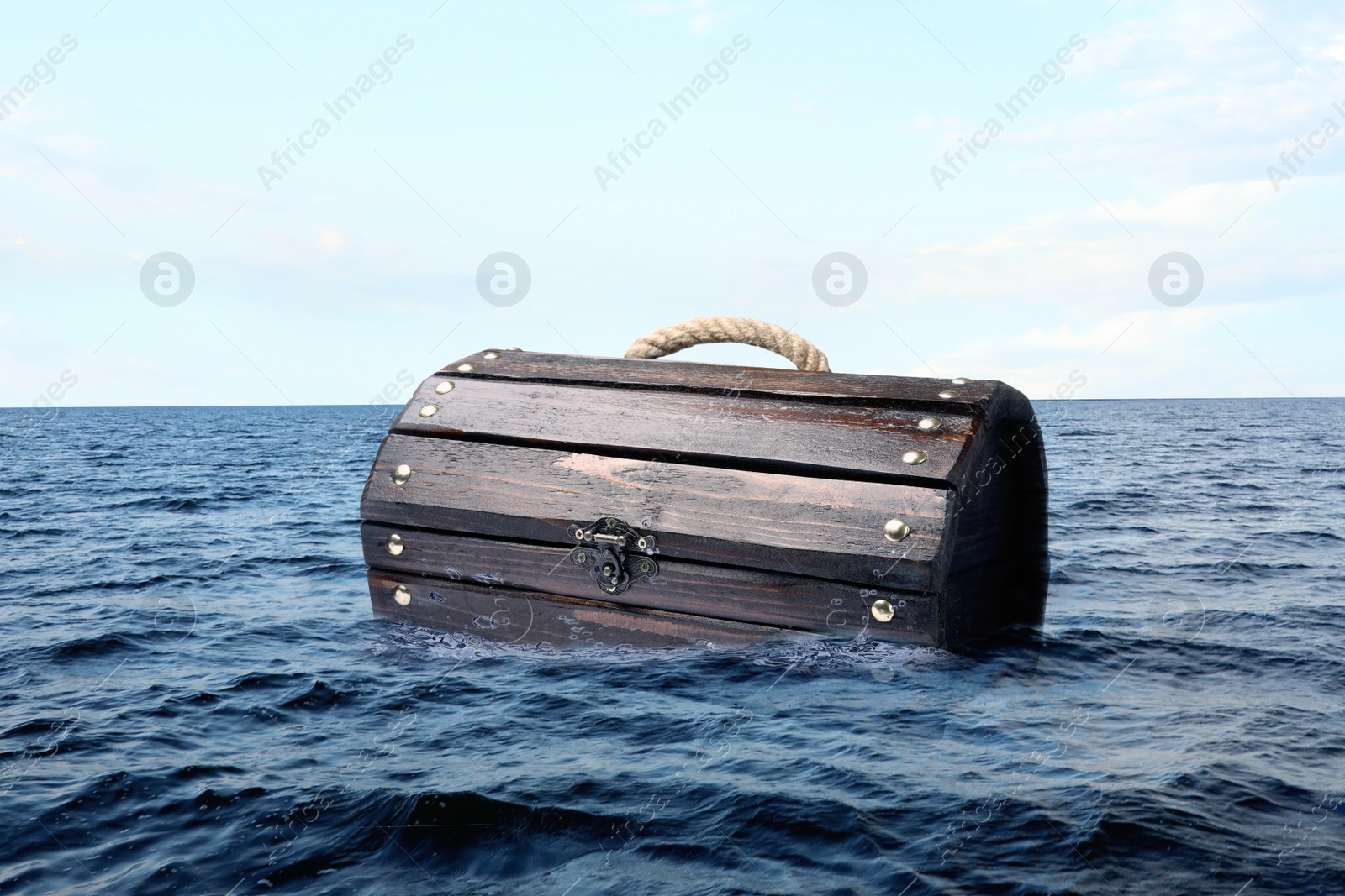 Image of Closed wooden treasure chest floating in sea