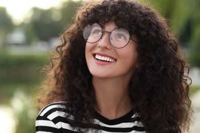 Portrait of beautiful woman in glasses on blurred background. Attractive lady smiling and posing for camera