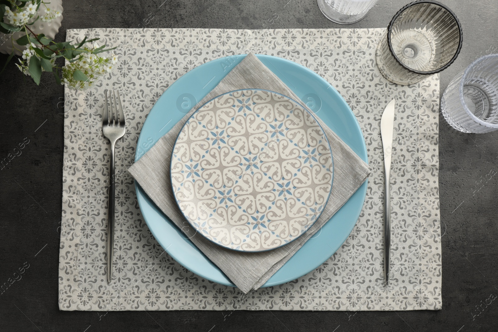 Photo of Stylish setting with cutlery, glasses and plates on black table, flat lay