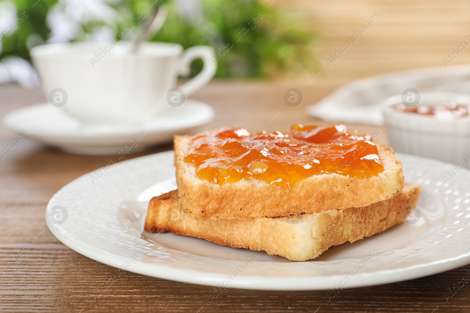 Photo of Bread with tasty apricot jam on plate