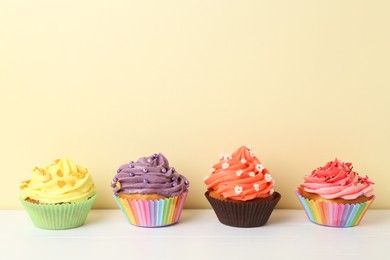 Delicious cupcake with bright cream on white wooden table. Space for text