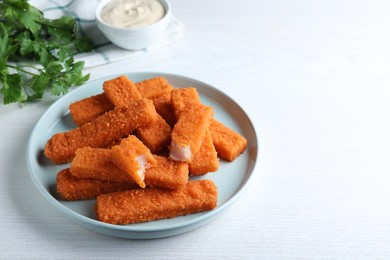 Photo of Fresh breaded fish fingers served on white table, space for text