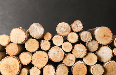 Photo of Cut firewood on black background. Heating in winter