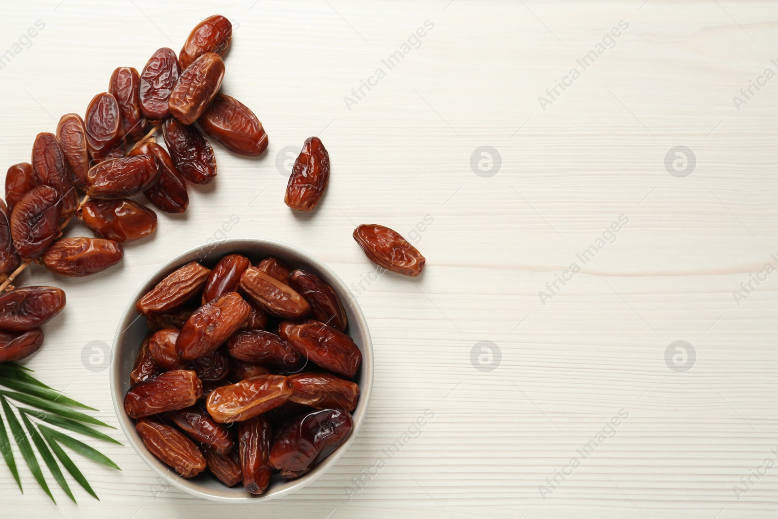 Photo of Flat lay composition with tasty sweet dried dates on white wooden table. Space for text