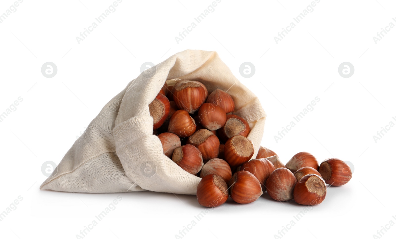 Photo of Overturned sack with tasty organic hazelnuts on white background