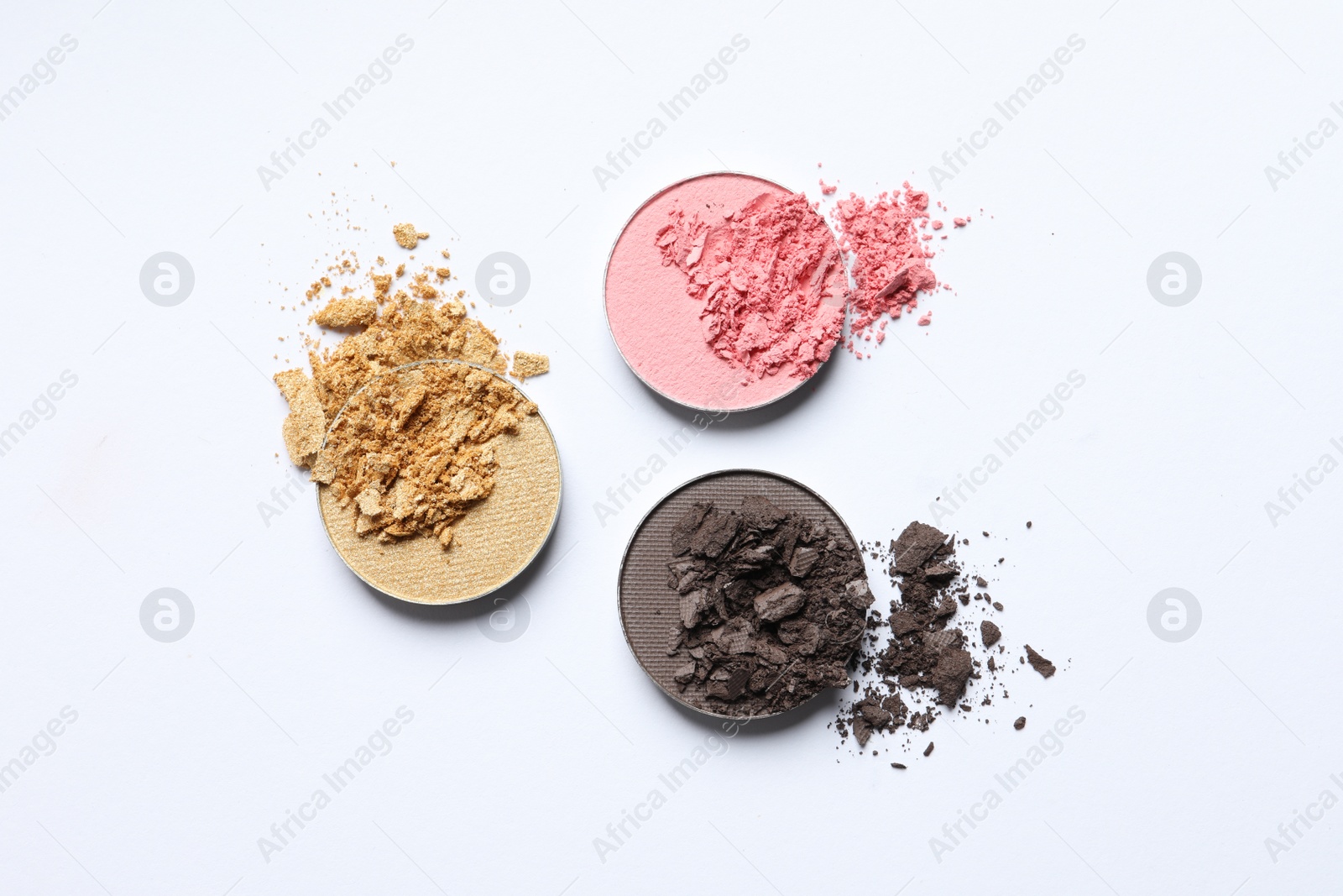 Photo of Different crushed eye shadows on white background, flat lay. Professional makeup product