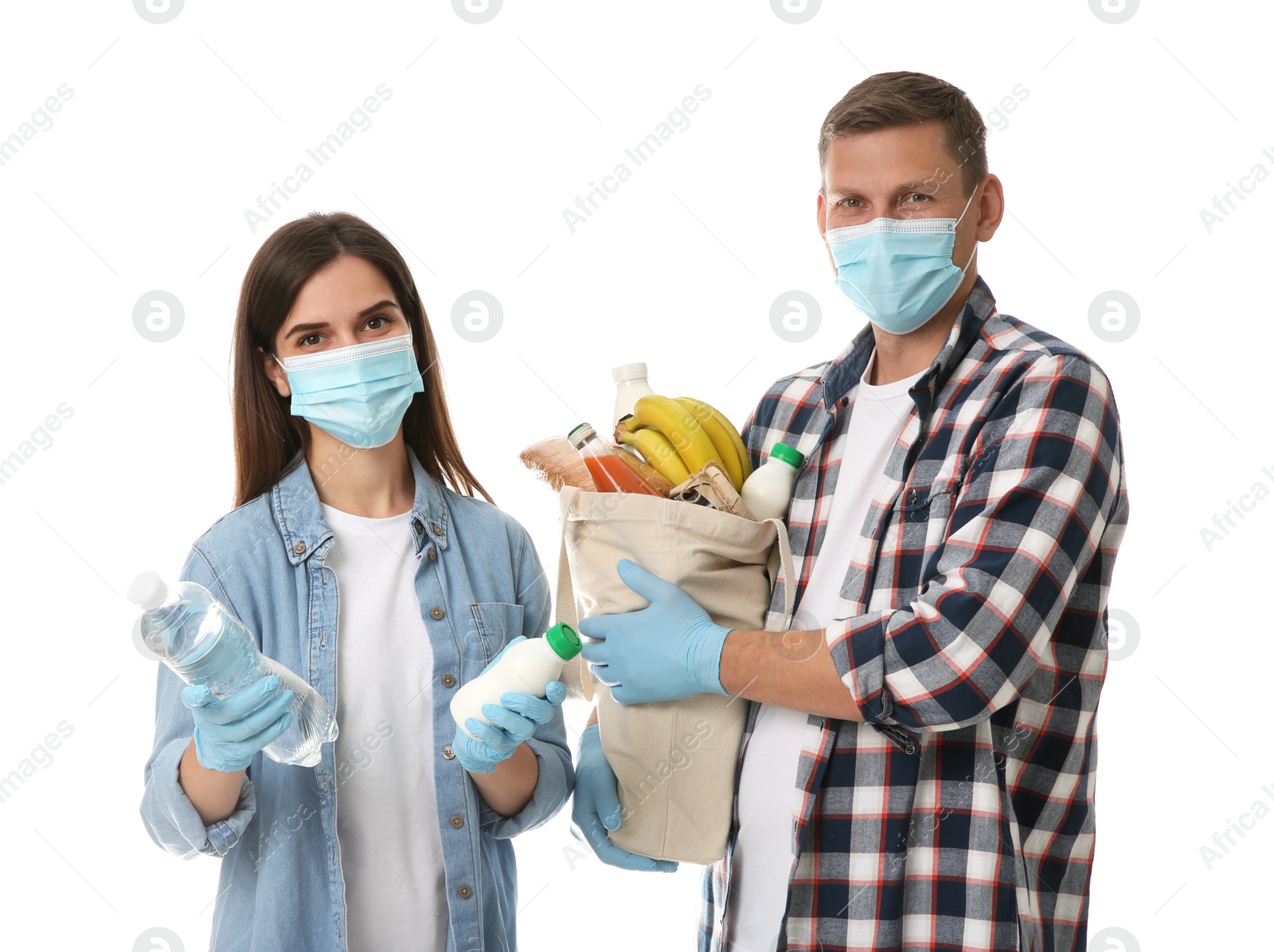 Photo of Volunteers in protective masks and gloves with products on white background. Aid during coronavirus quarantine