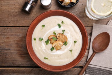 Photo of Delicious cream soup with mushrooms served on wooden table, flat lay
