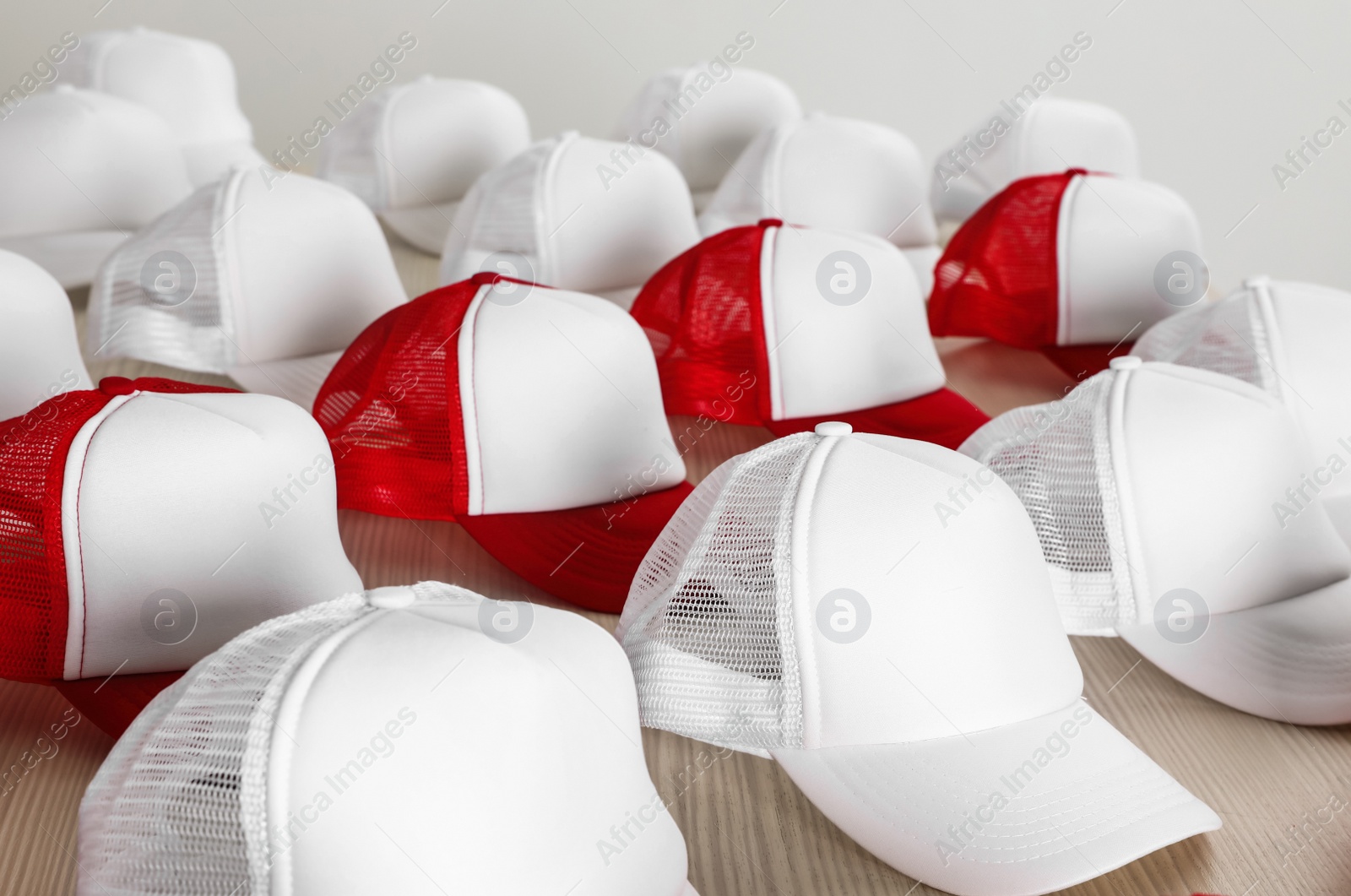 Photo of Many blank caps on wooden table. Mock up for design