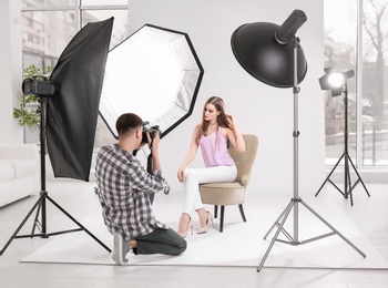 Beautiful young model posing for professional photographer in studio