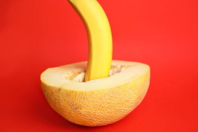 Fresh banana and melon on red background. Sex concept