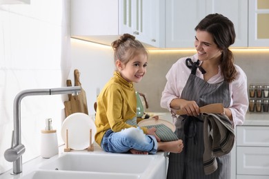 Young mother and her daughter spending time together in kitchen