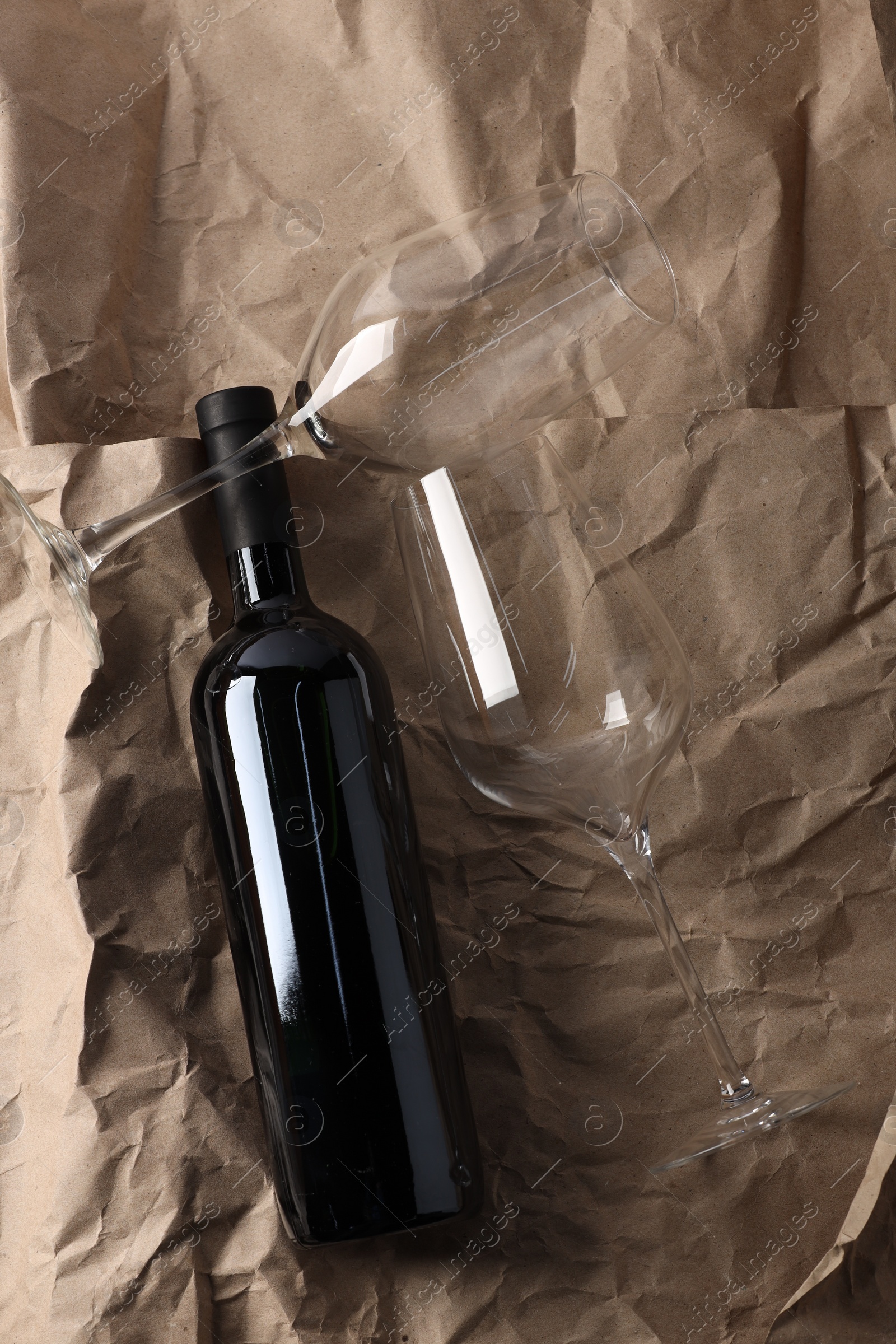 Photo of Stylish presentation of delicious red wine in bottle and glasses on paper background, top view