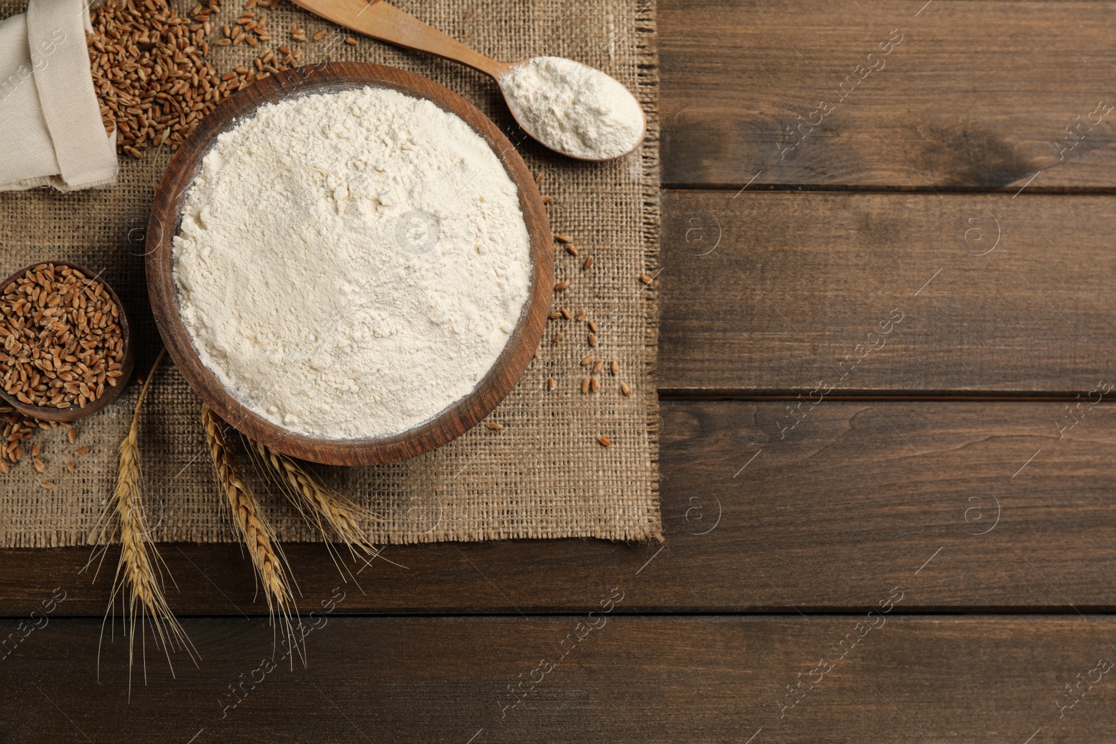 Photo of Flat lay composition with wheat flour on wooden table. Space for text