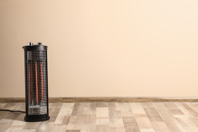Photo of New modern electric heater on floor in room, space for text