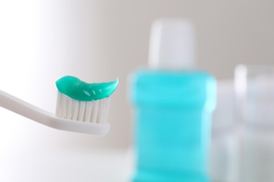 Photo of Toothbrush with paste on blurred background, closeup. Space for text