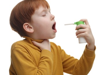 Little boy using throat spray on white background