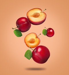 Image of Many fresh cherry plums falling on orange background