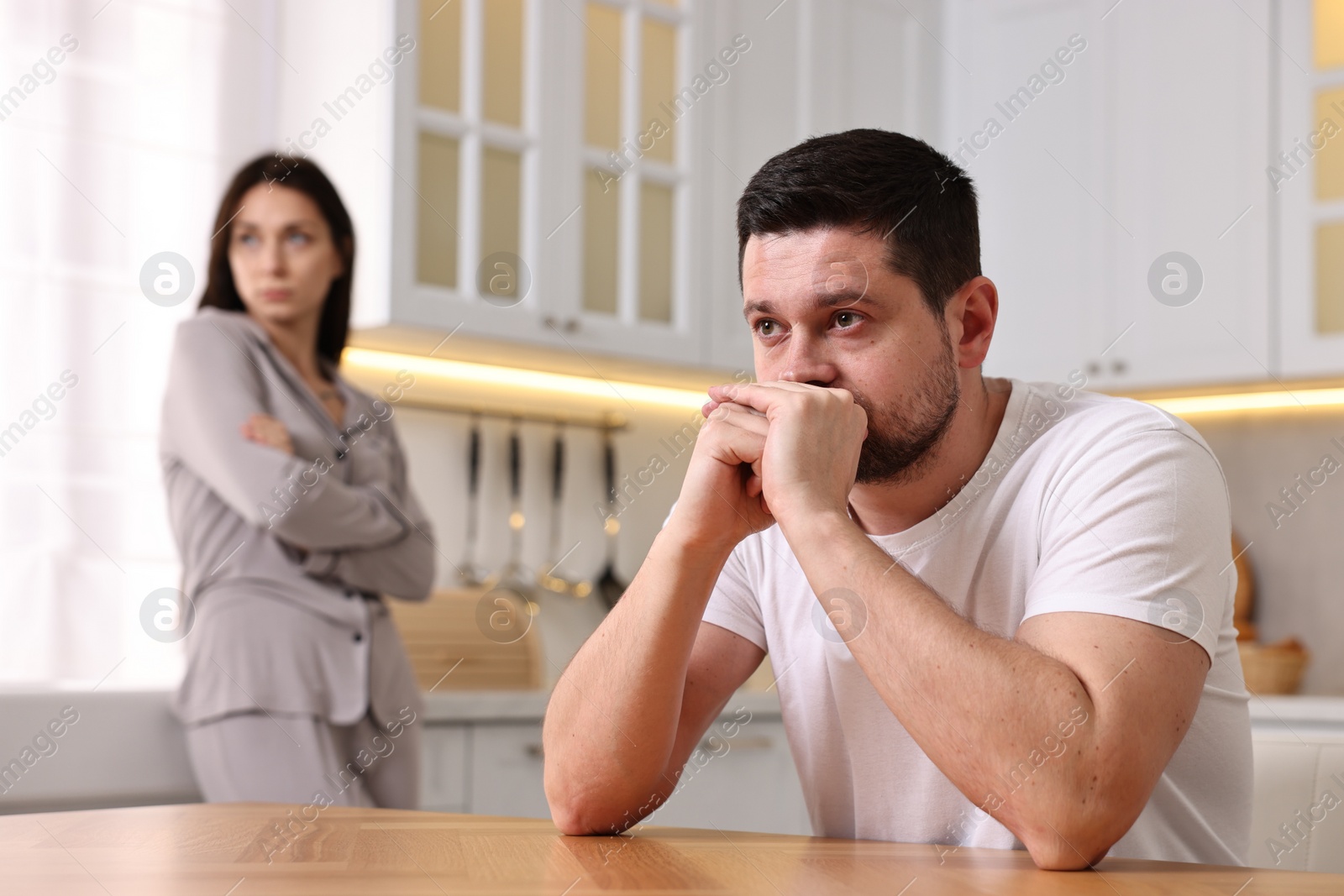 Photo of Offended couple ignoring each other after quarrel in kitchen, selective focus. Relationship problems