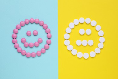 Photo of Sad and happy emoticons made of antidepressants on colorful background, flat lay