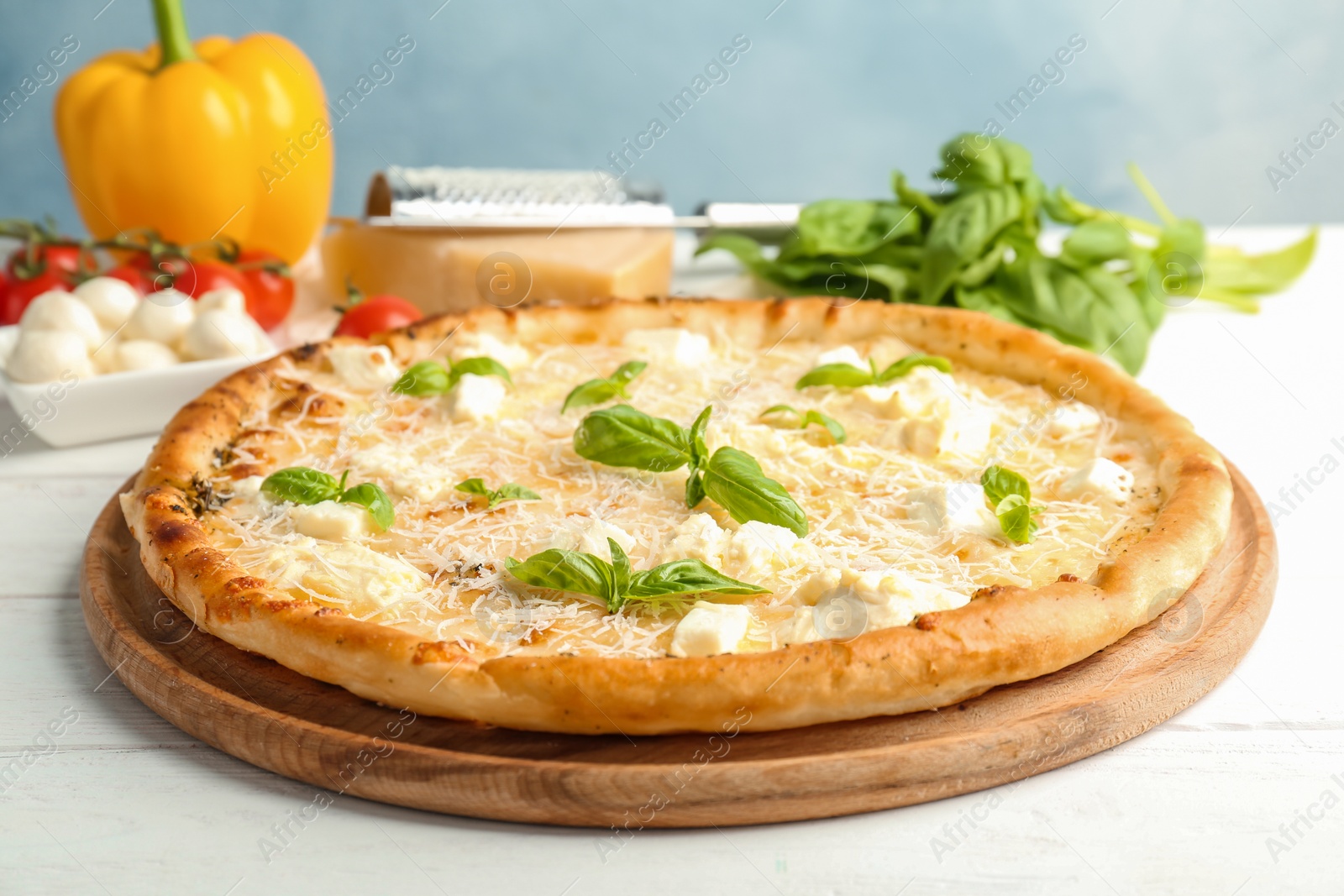 Photo of Delicious pizza with cheese and basil on table