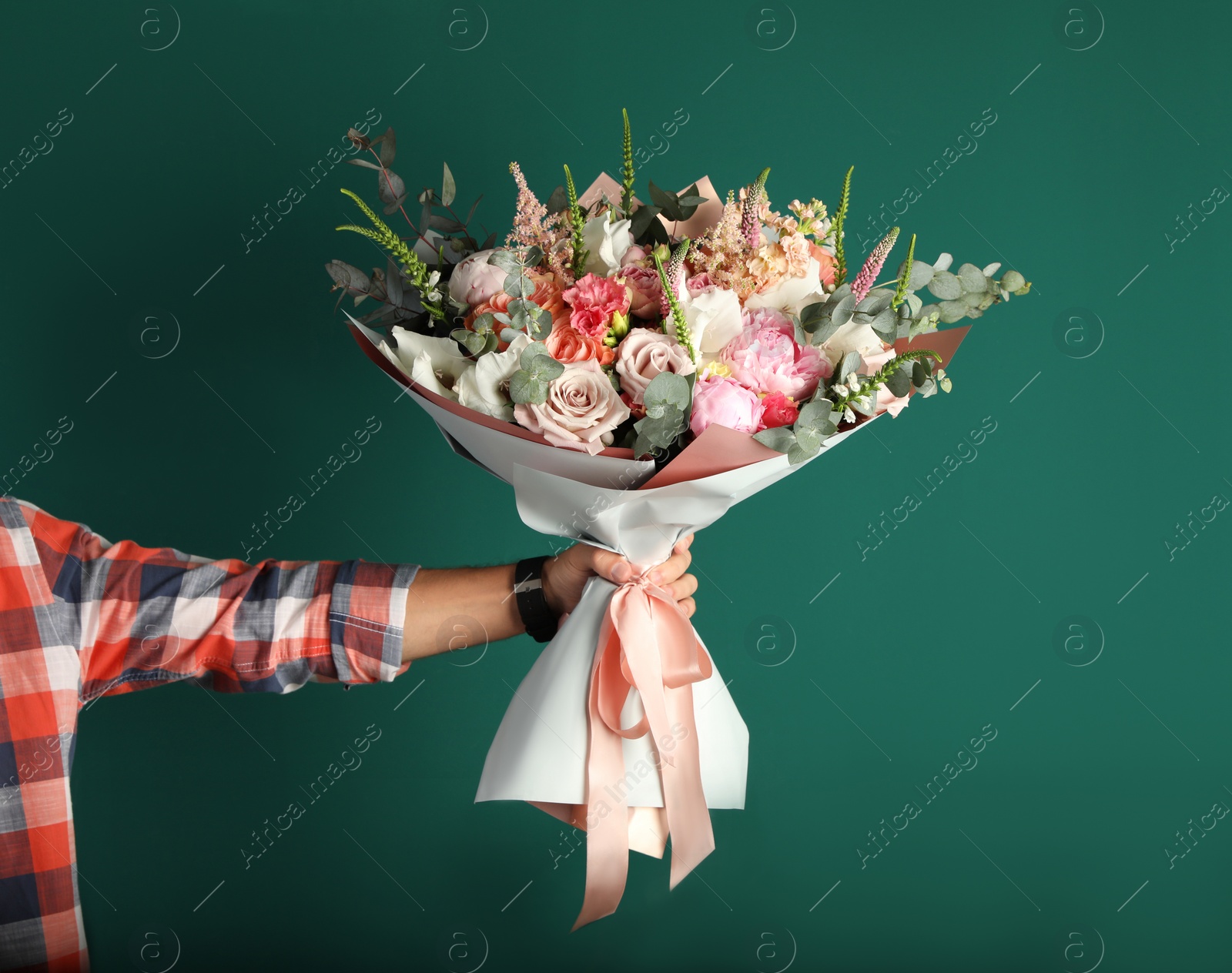 Photo of Man holding beautiful flower bouquet on green background, closeup view