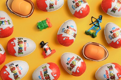 Photo of Sveti Vlas, Bulgaria - June 26, 2023: Kinder Surprise Eggs, plastic containers and toys on orange background, flat lay