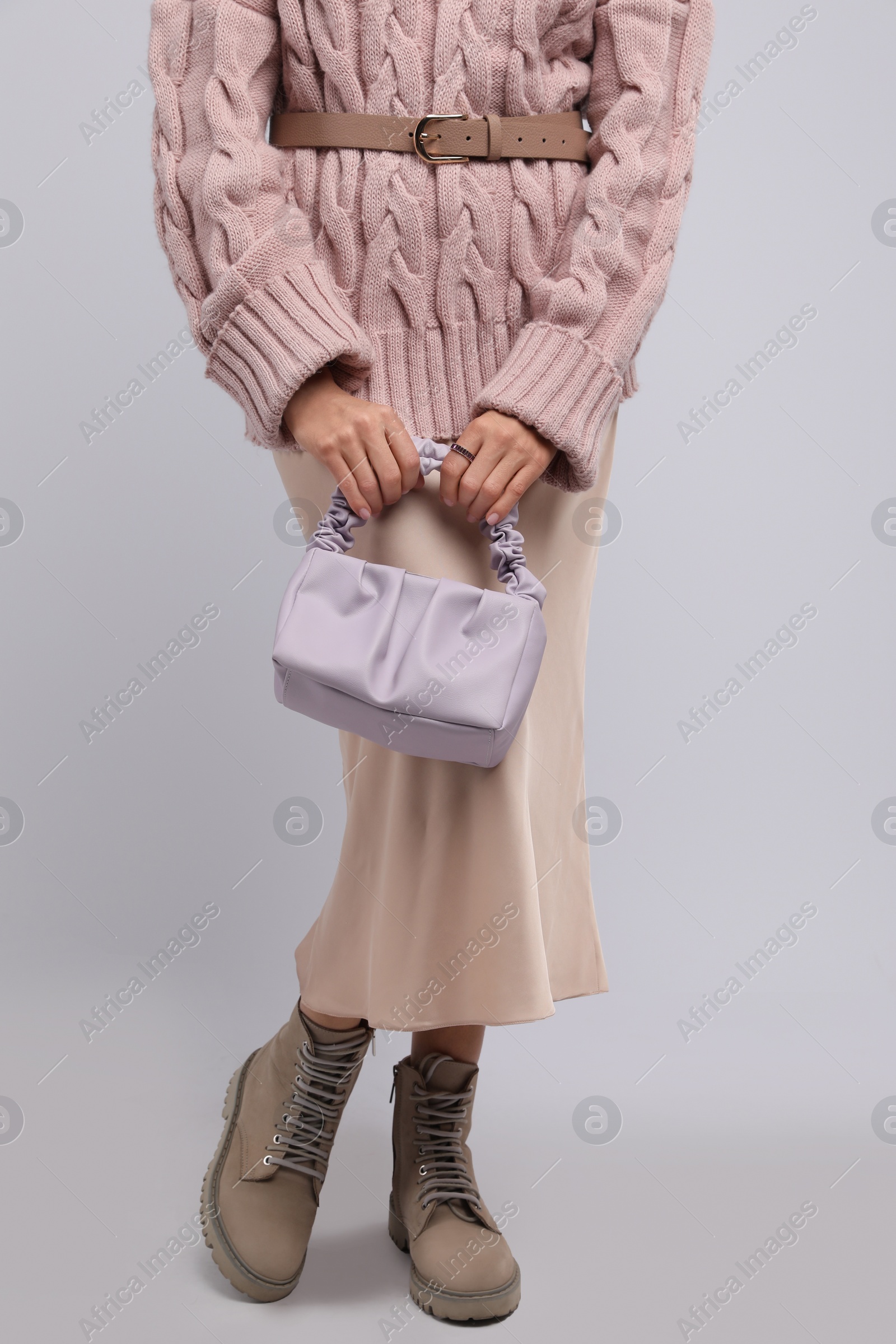 Photo of Fashionable woman with stylish bag on light background, closeup